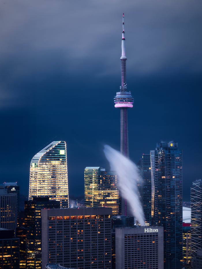services-01 Dramatic night view of Toronto's skyline with the iconic CN Tower and illuminated skyscrapers.